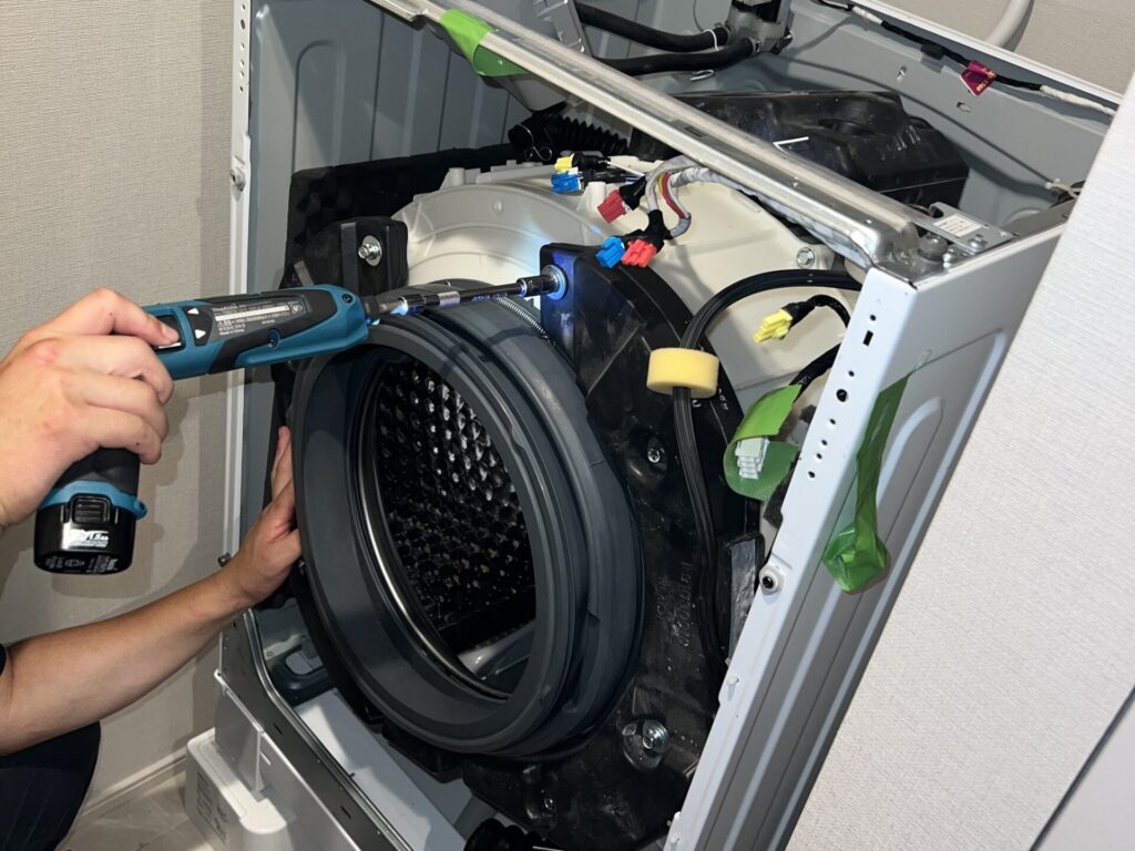 洗濯機の分解洗浄専門業者「洗濯機のまじん」がドラム式洗濯機を分解している様子