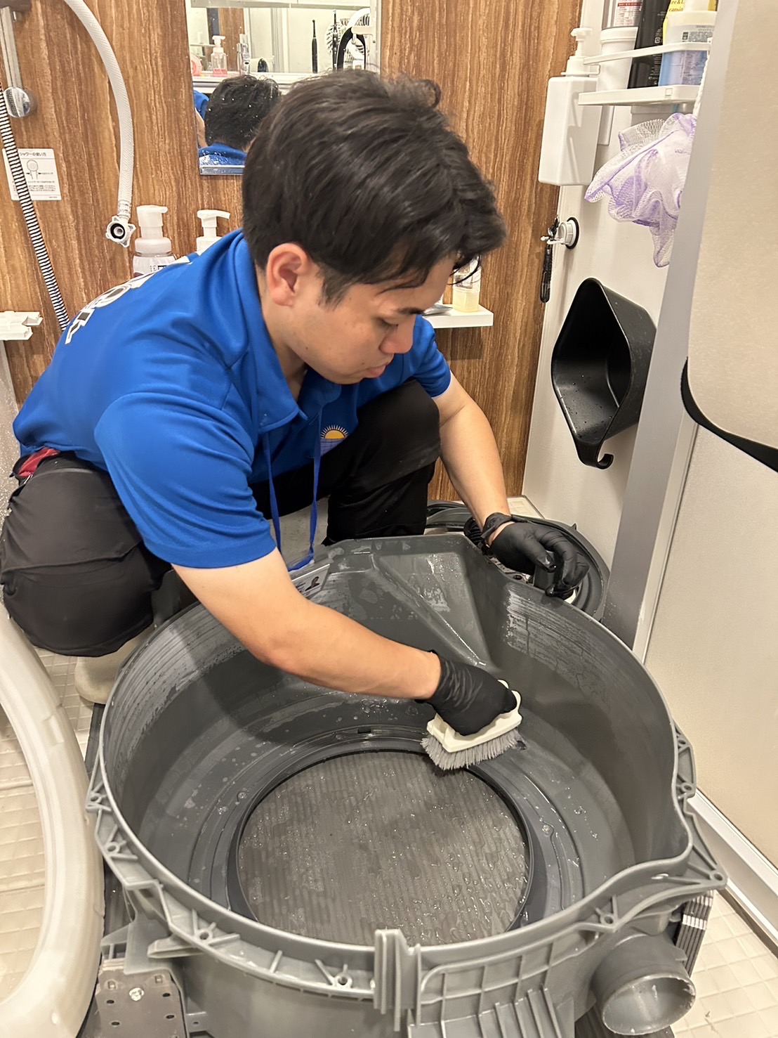 取り外した洗濯槽を洗浄するスタッフ