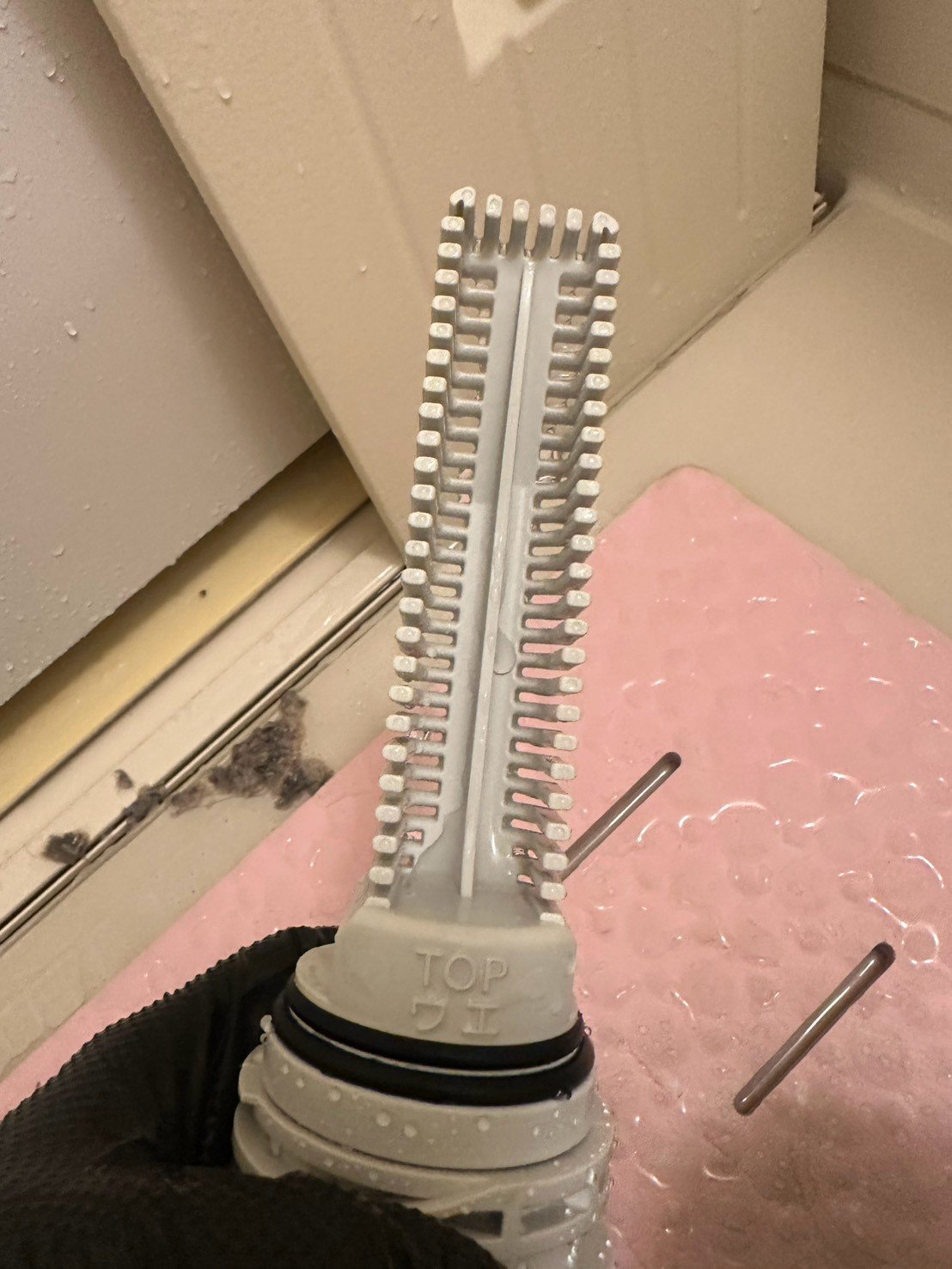 洗浄後の同じ部品。汚れが落ちて白い樹脂の色に戻っている